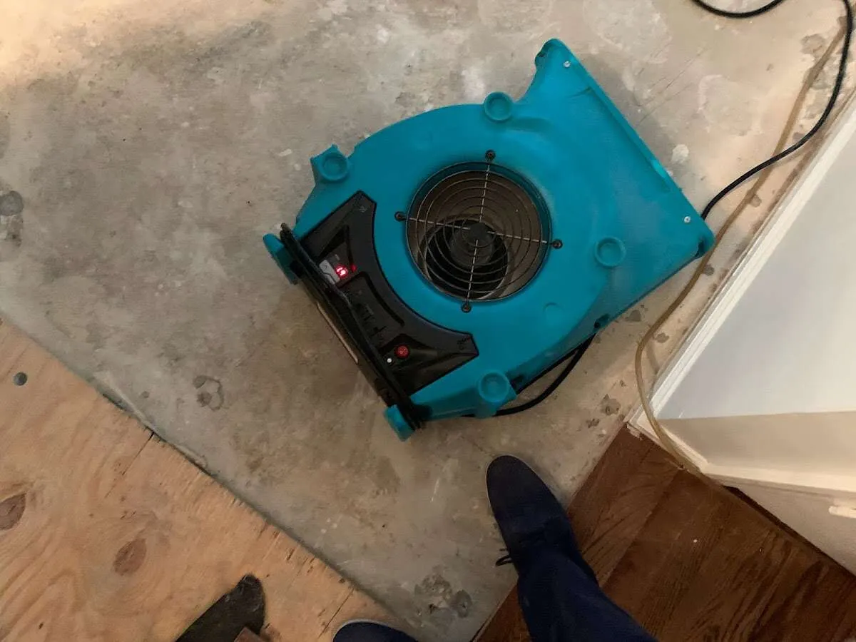 Air mover drying subfloor during Leak Detection & Repair in Laketown